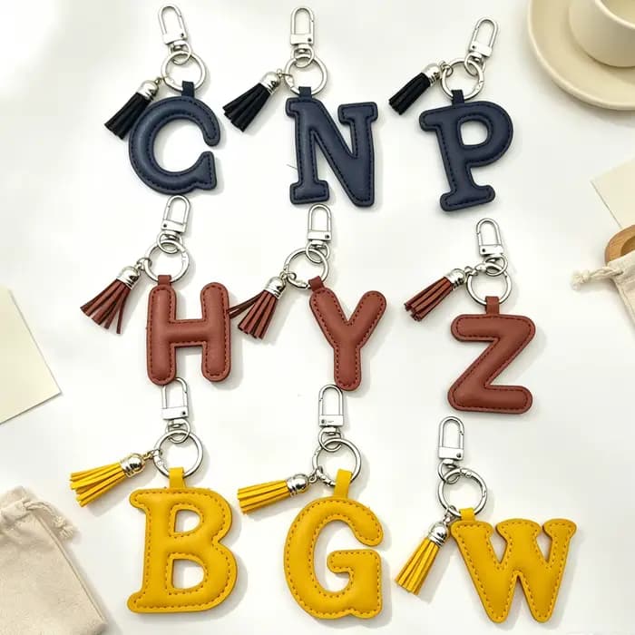 Porte-clés en cuir avec initiale A-Z, mini pompon décoratif, couleur unie, alphabet, ornement de sac à dos, cadeau pour fille